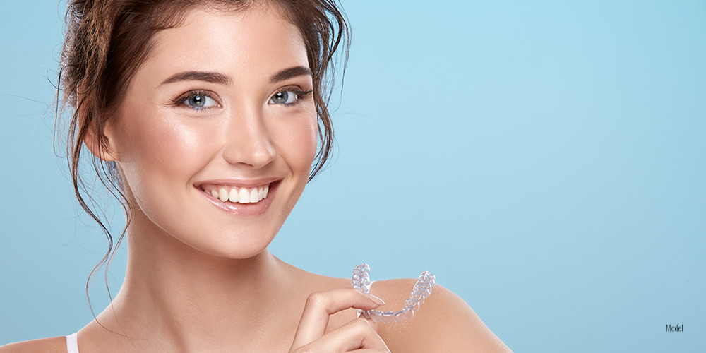 Female holding Invisalign in her hand