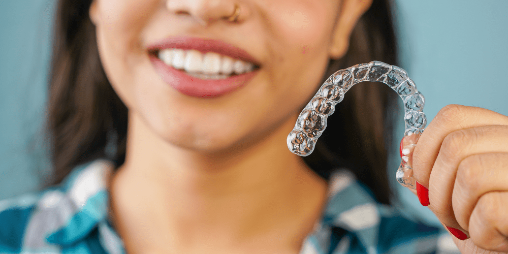 woman holding Invisalign braces